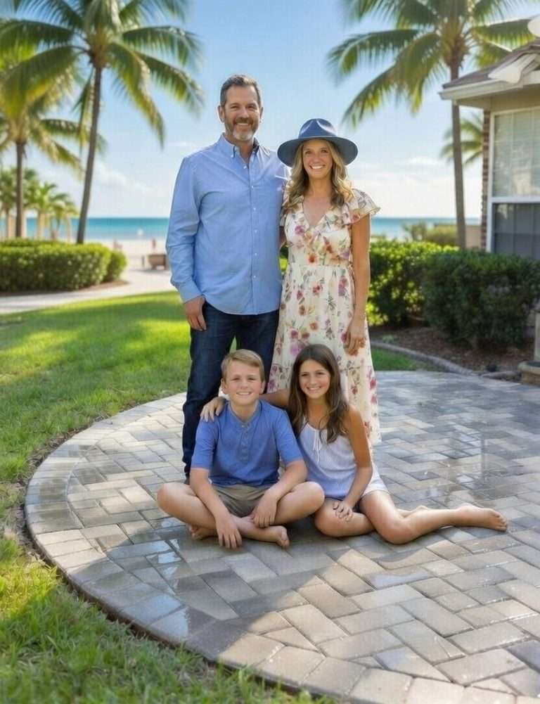 Happy family posing on their beautiful new interlocking paver patio with ocean views in Florida — professional paver installation completed in a coastal backyard