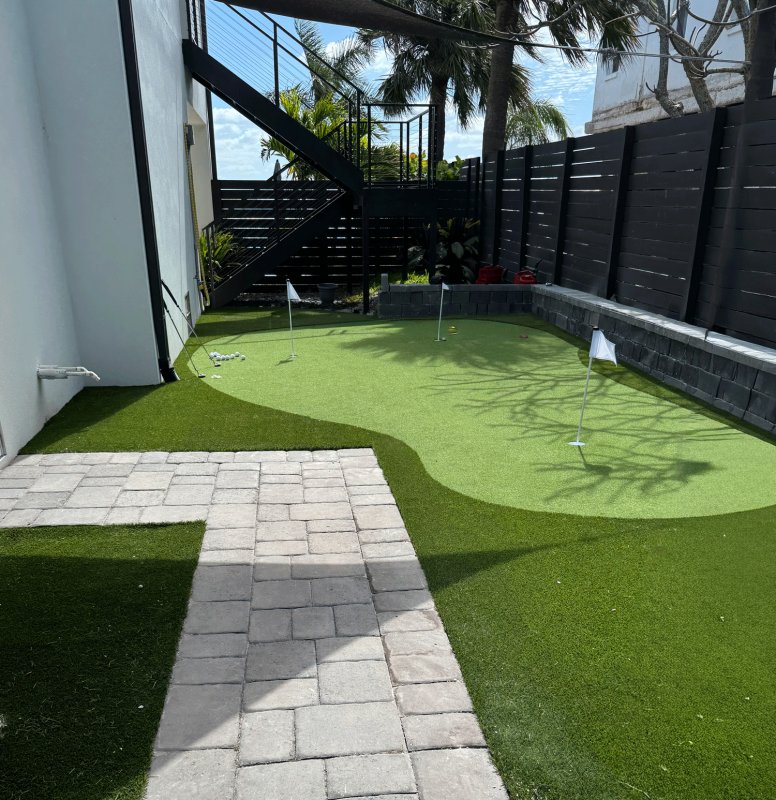 A beautifully designed landscape and synthetic putting green in a St. Pete Beach residential backyard.