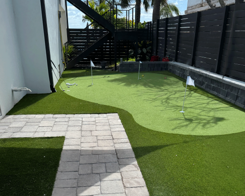 A beautifully designed landscape and synthetic putting green in a St. Pete Beach residential backyard.
